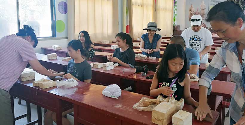 Hands shaping terracotta clay in Xi’an